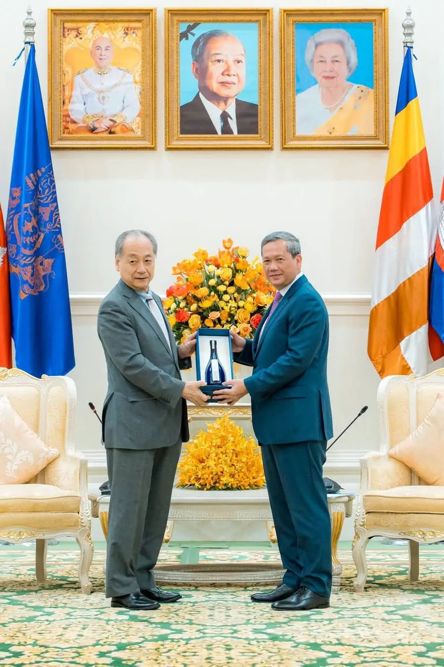 山口県発の長期熟成型ヴィンテージ日本酒「夢雀」をカンボジア王国のフンマネット首相(右)に手渡す高橋会長(左)